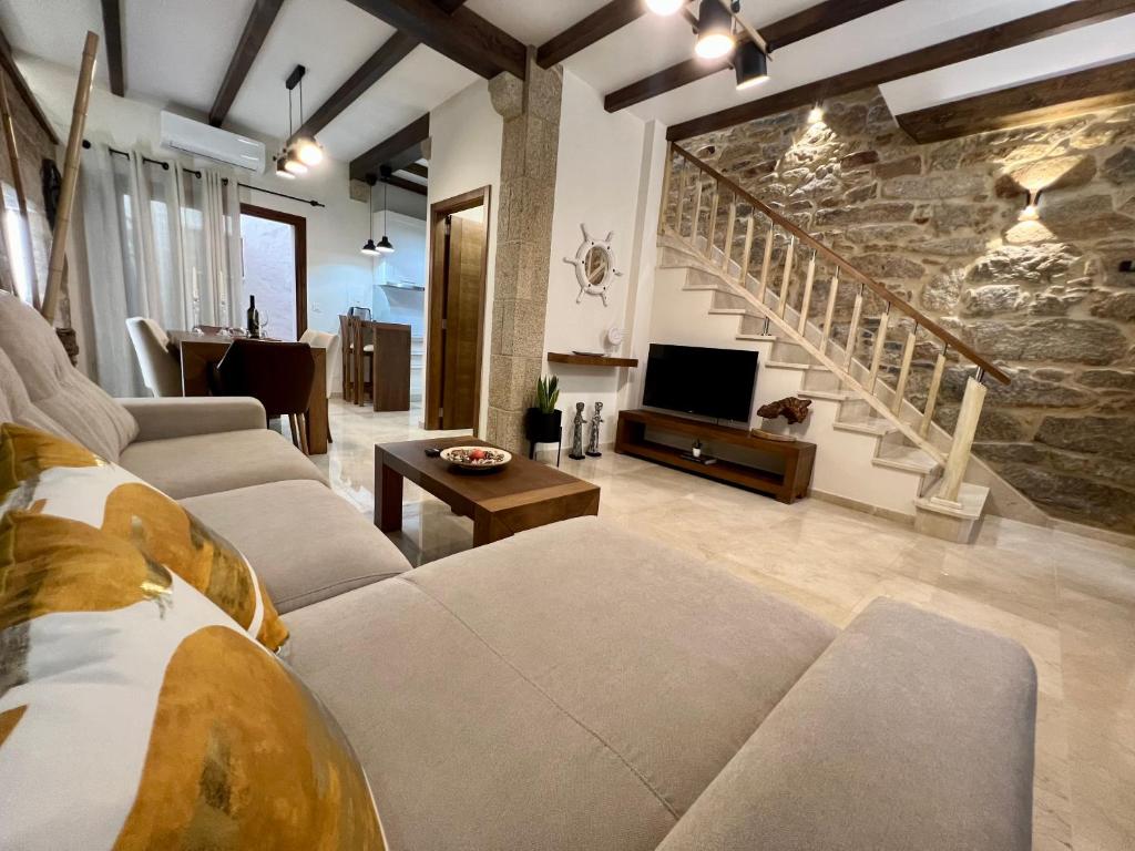 维拉加尔西亚·德·阿劳萨Preciosa casa marinera en Carril的带沙发和石墙的客厅
