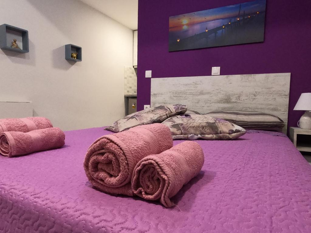 科孚镇MEMORIA的紫色的床,上面有毛巾