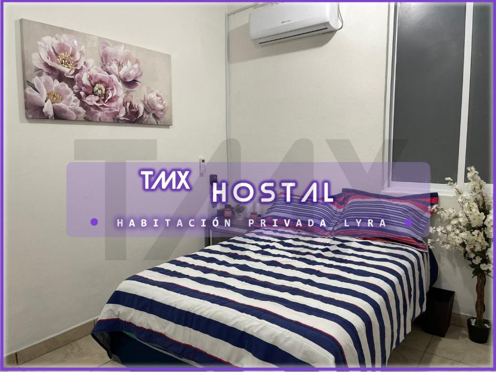 埃斯孔迪多港TMX HOSTAL的一间卧室配有一张床,并展示着鲜花