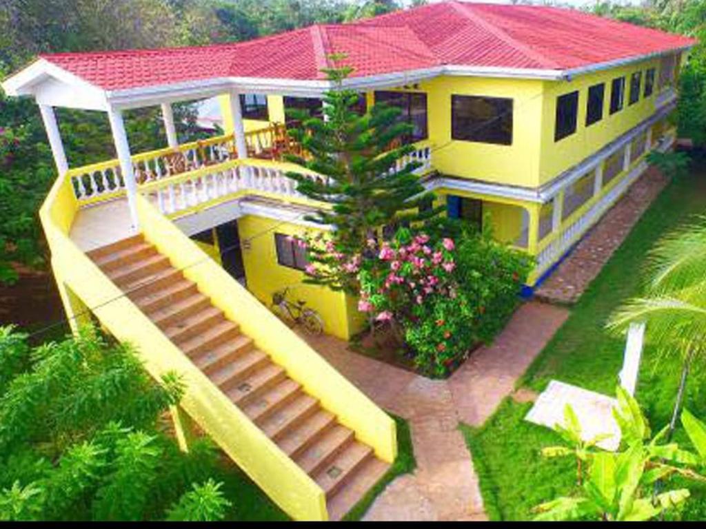 小玉米岛Sunshine Hotel Little Corn Island的一座黄色的大房子,有楼梯通往