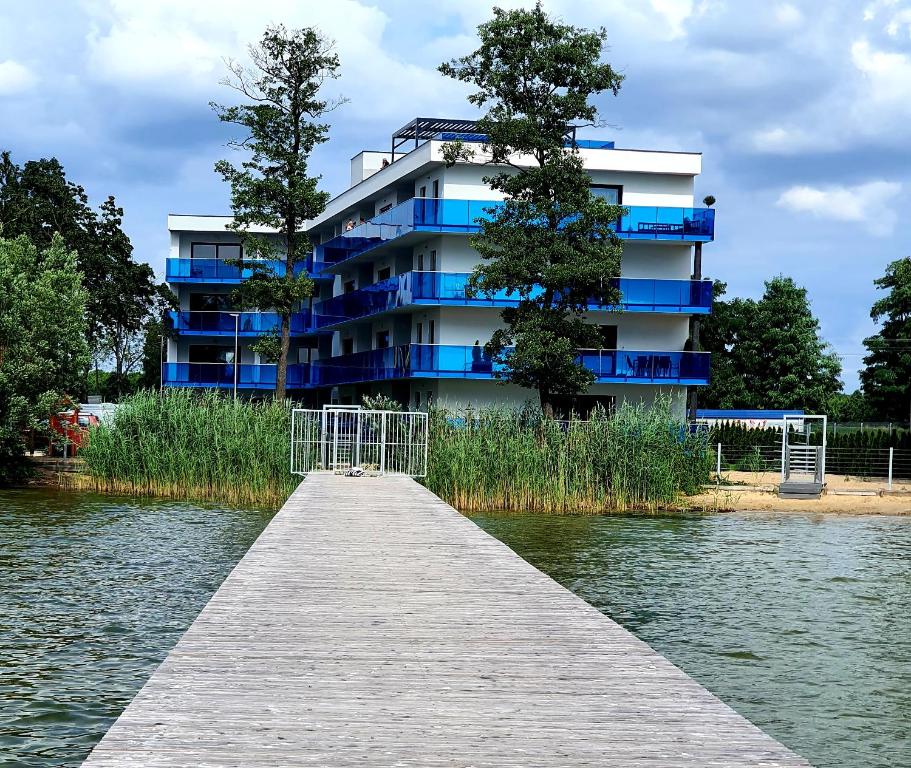 博茨科沃Apartamenty Aquarius Gold Boszkowo的水体旁的一座有码头的建筑