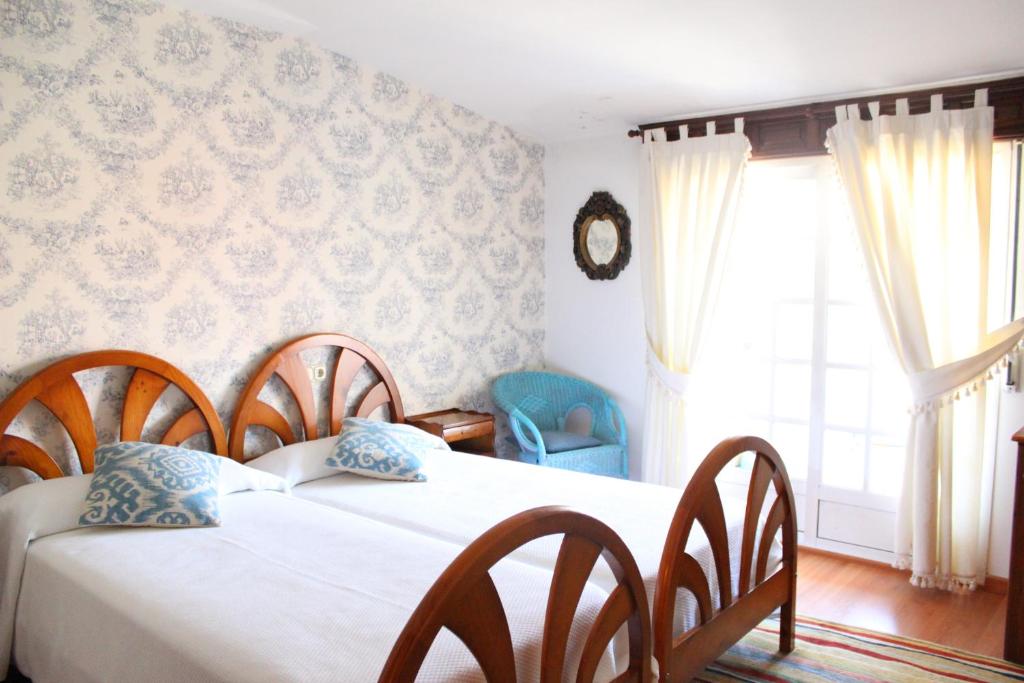 坎巴多斯塔伊娜公寓式酒店的一间卧室设有两张床和窗户。