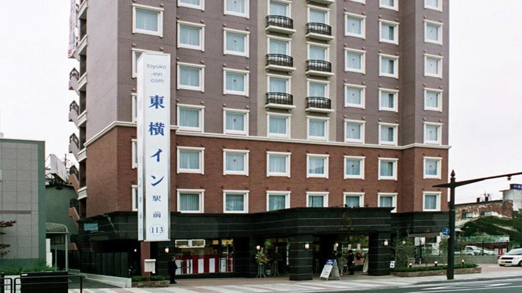 上田市Toyoko Inn Ueda Ekimae的前面有标志的大建筑