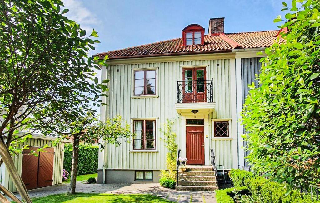 哥德堡Amazing Home In Gteborg With Wifi的一间白色的小房子,有红色的门