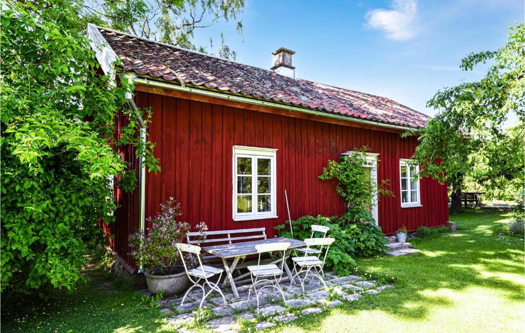 利雪平Amazing Home In Lidkping With Kitchen的一间红色的房子,前面设有一张野餐桌