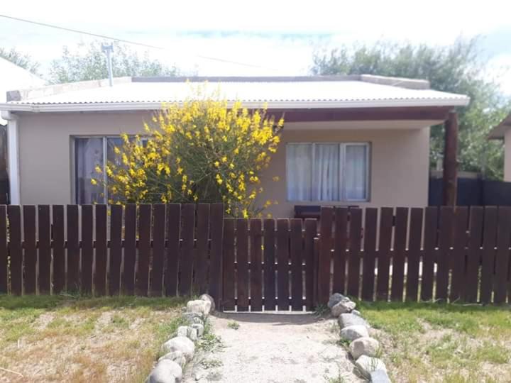 埃尔卡拉法特My House in El Calafate的房屋前的木栅栏