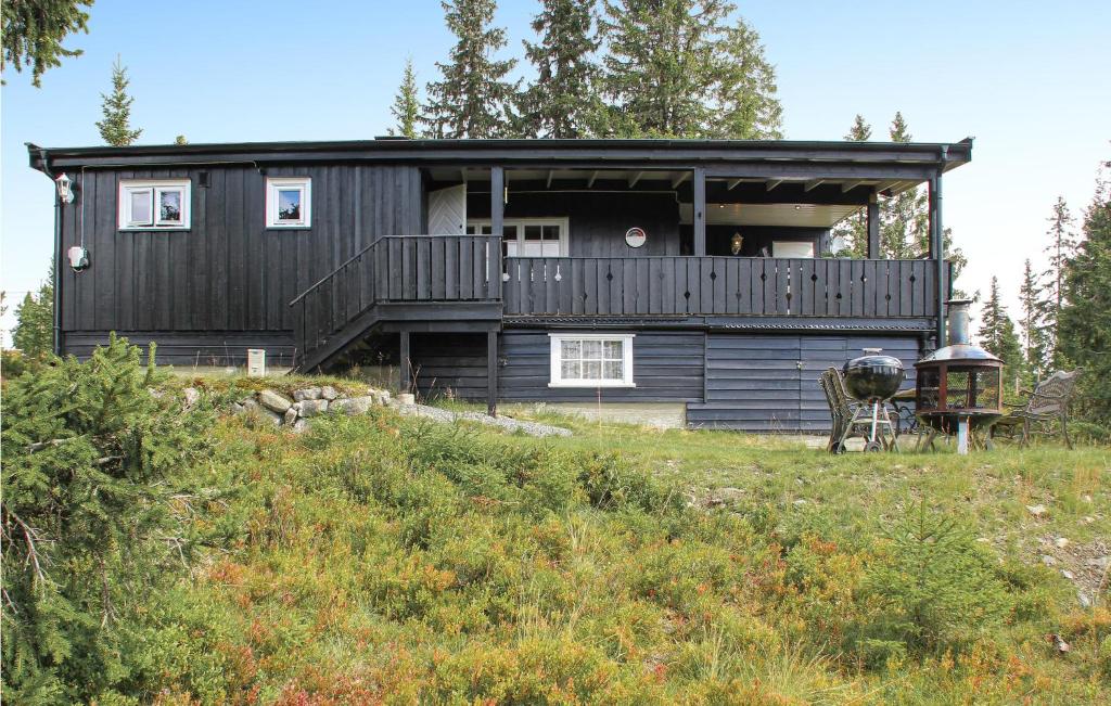斯朱森Gorgeous Home In Sjusjen With Wifi的山上带甲板的黑色房子