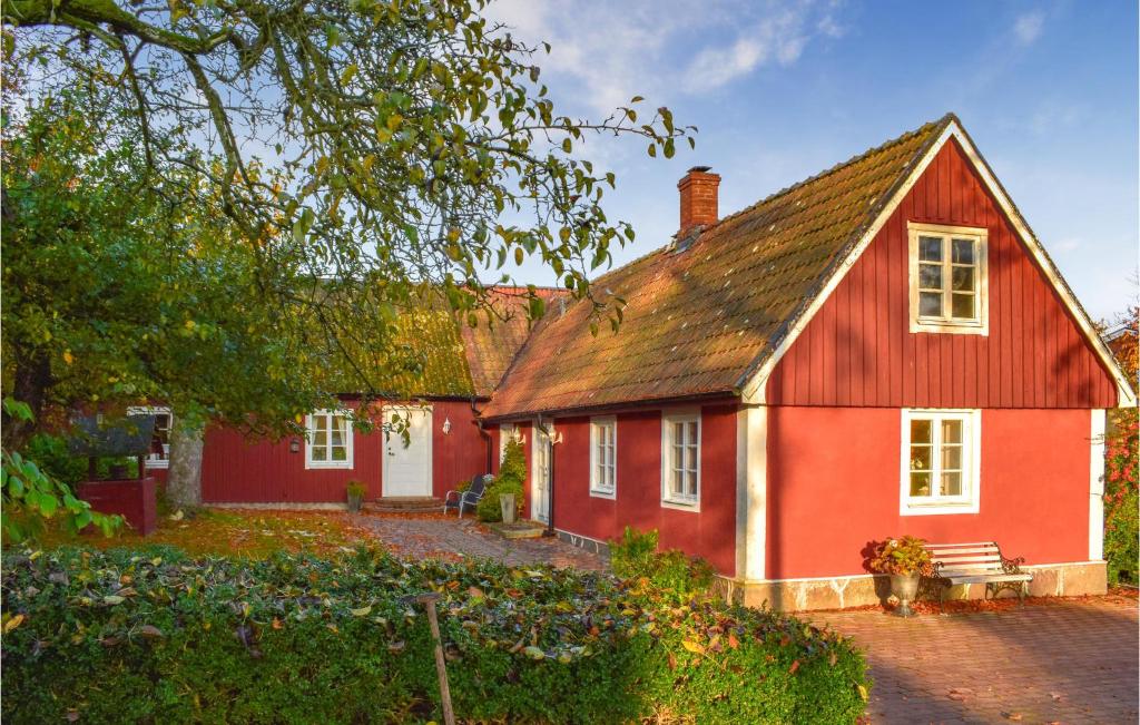 斯塔德Stunning Home In Ystad With Sauna, 3 Bedrooms And Wifi的前面有长凳的红色房子