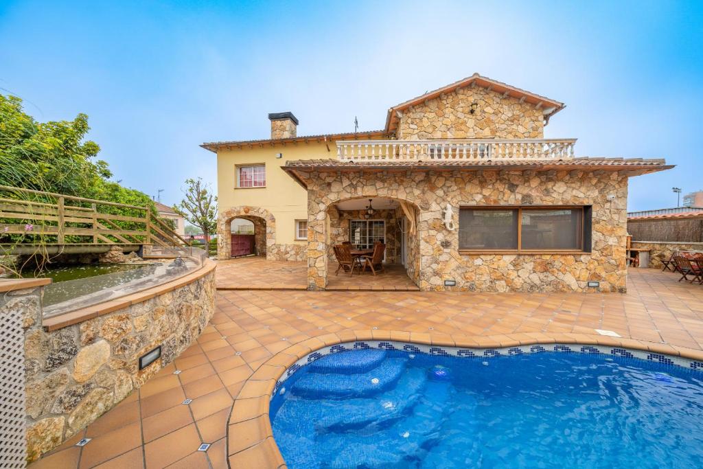 布拉内斯HomeHolidaysRentals Romeo - Costa Brava的一座石头房子,在院子里设有游泳池
