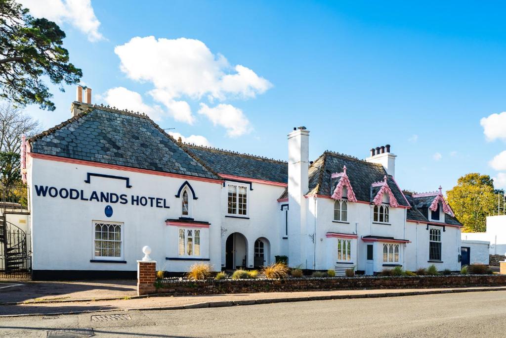 锡德茅斯伍德兰德酒店的白色的旅馆,上面标有读林地的标志
