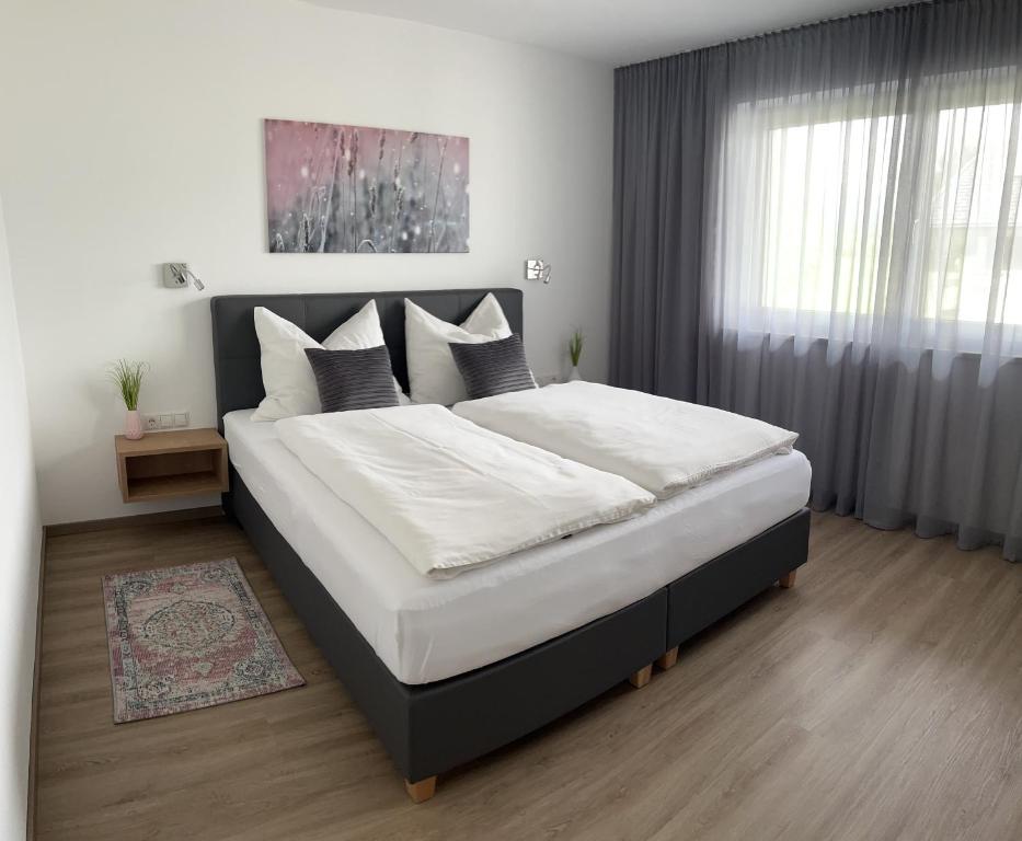 埃布斯Ferienwohnung Ott的卧室配有一张带白色床单和枕头的大床。