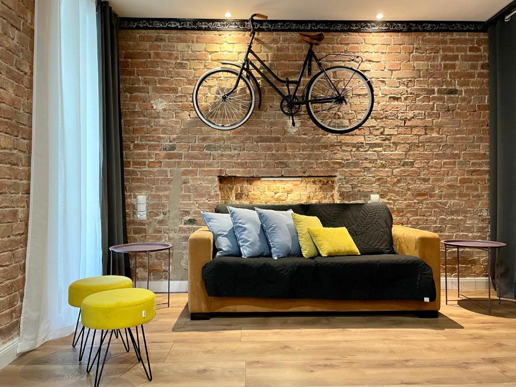 托伦Petite Viste No. 3 Apartment的挂在沙发上方砖墙上的自行车