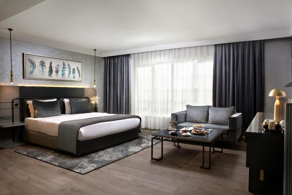 安卡拉The Wings Hotels Neva Palas的一间卧室配有一张床、一张沙发和一张桌子