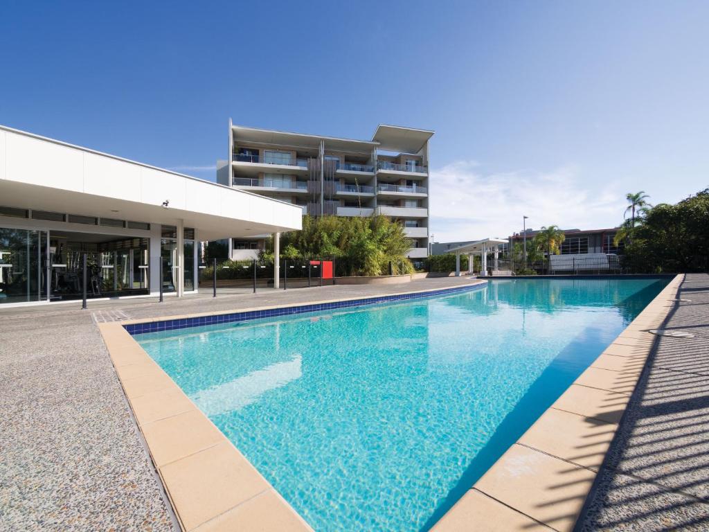 布里斯班Oaks Brisbane Mews Suites的大楼前的大型游泳池