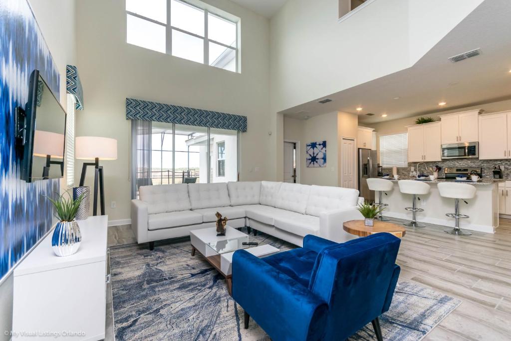 基西米Beautiful Home wPrivate Pool & Spa, near WDW的客厅配有白色沙发和蓝色椅子