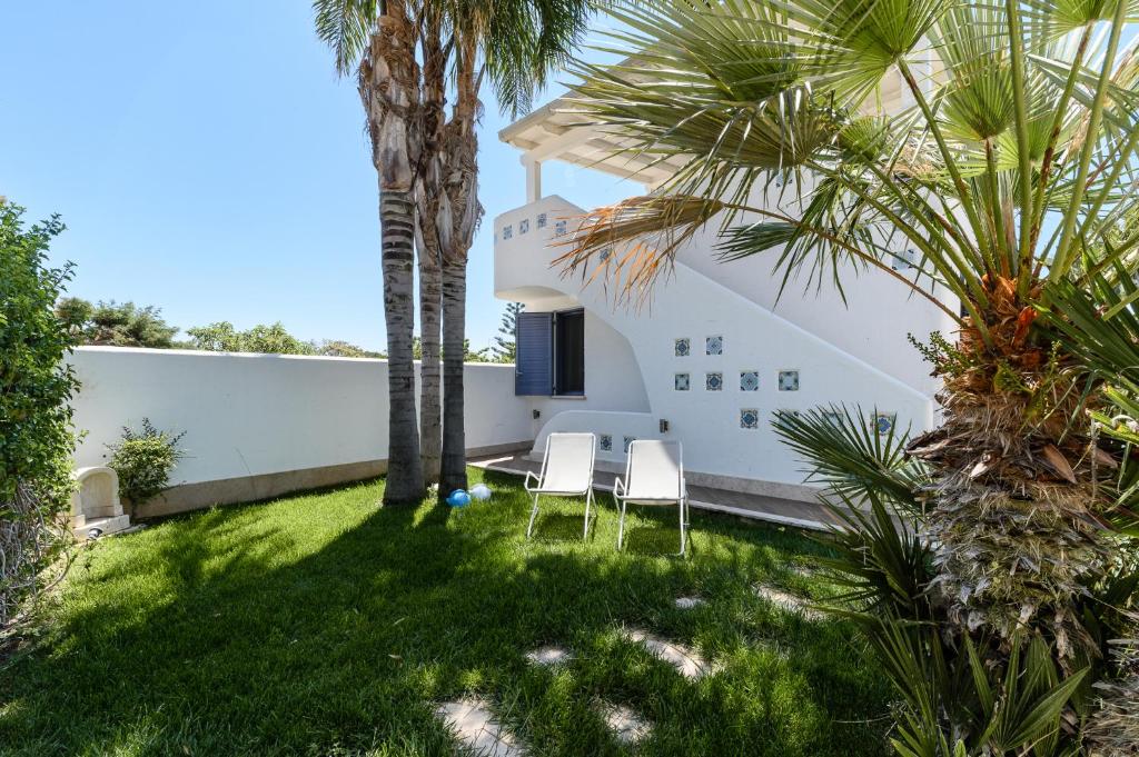 斯培基奥拉Casa Maiolica的一个带两把椅子的庭院,棕榈树