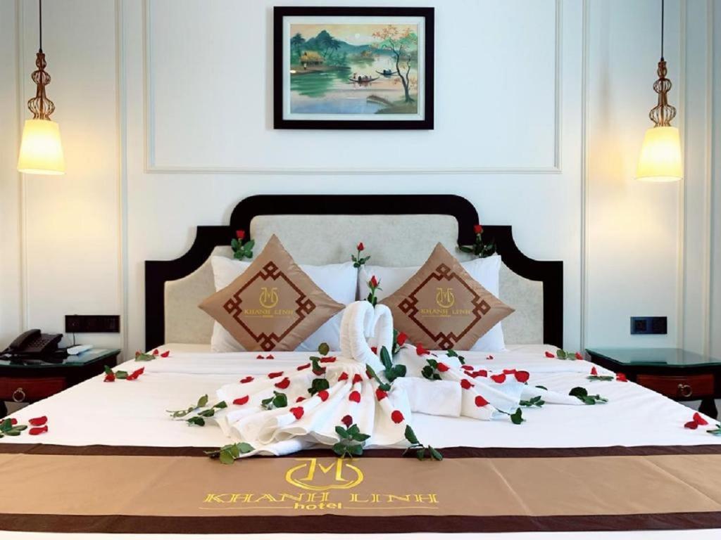 岘港Khanh Linh Hotel的一间卧室配有一张带鲜花的大床