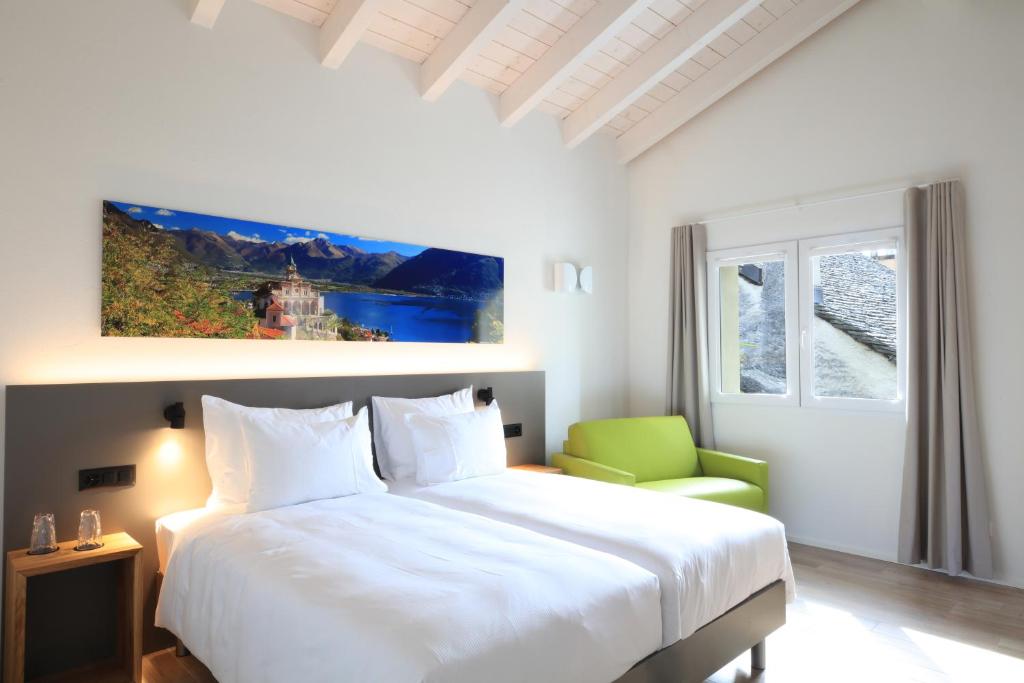 阿斯科纳Charme Hotel al Torchio的卧室配有白色的床和绿色椅子