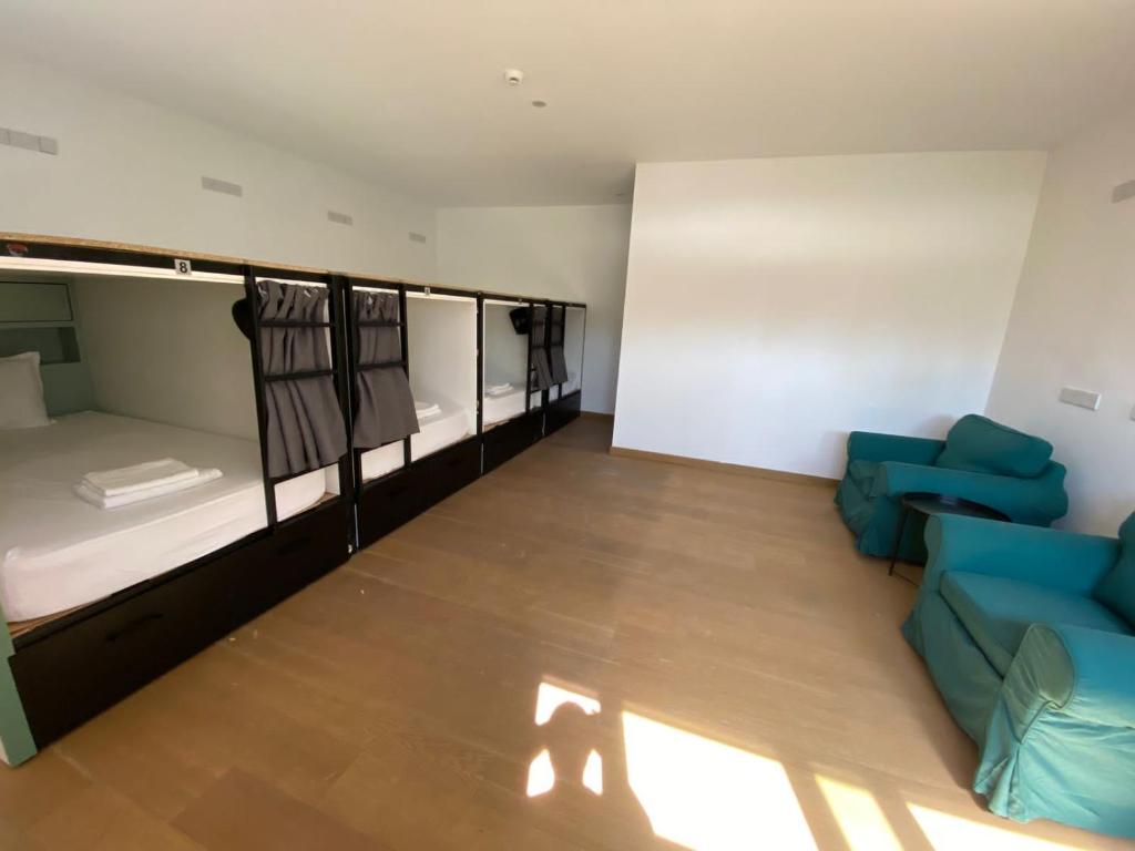 尼科西亚Urban Habitat Capsule Beds的带三张双层床和一张沙发的房间
