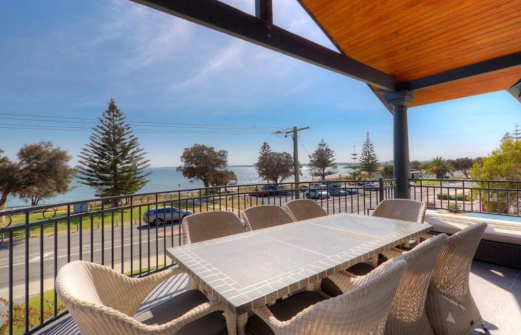 曼哲拉Beachfront Family Favourite Home with Pool & Views的海景阳台上的桌椅