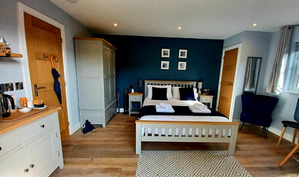 卡比斯贝Stylish coastal retreat in St Ives的一间卧室设有一张床和蓝色的墙壁