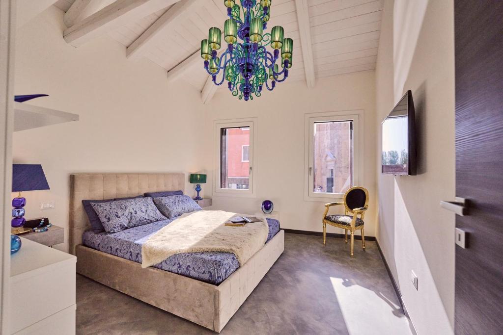 穆拉诺Simone Cenedese Murano Apartments - Cristallo的一间卧室配有一张大床和一个吊灯。