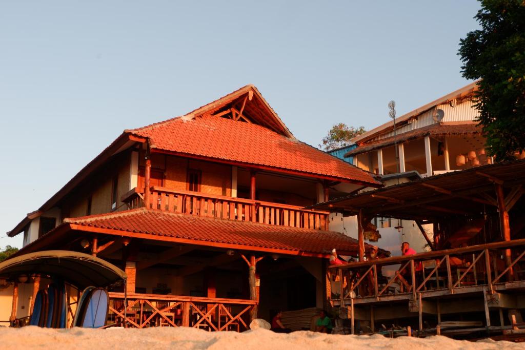 金巴兰三台巴厘岛旅馆的一座大型木房子,设有红色屋顶