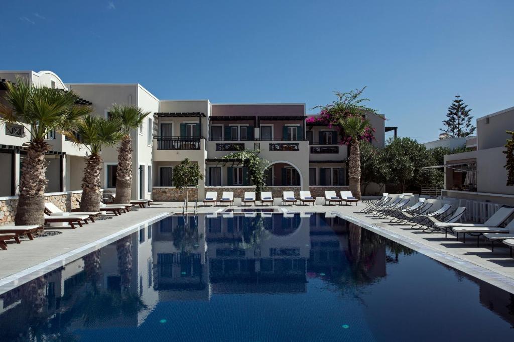 卡马利玫瑰湾酒店的一座带躺椅的游泳池和一座建筑