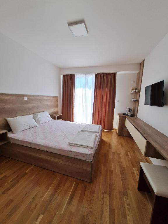 内戈蒂诺Bojana Apartment Penthouse的一间卧室设有一张大床,铺有木地板