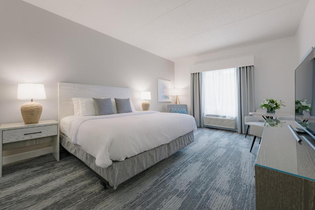 贝瑟尼滩Hotel Bethany Beach的白色卧室配有一张大床和一张书桌