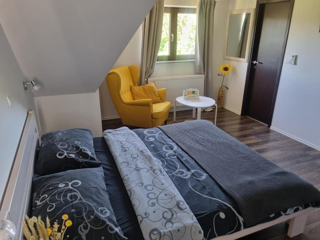 拉科维察四季旅馆的一间卧室配有一张床和一张黄色椅子