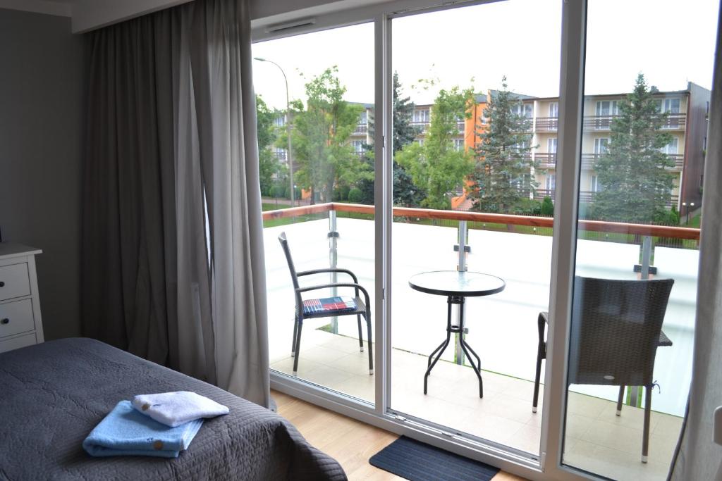 达洛科Darłówko Apartament Morski VI的一间卧室设有一张床,享有阳台的景色