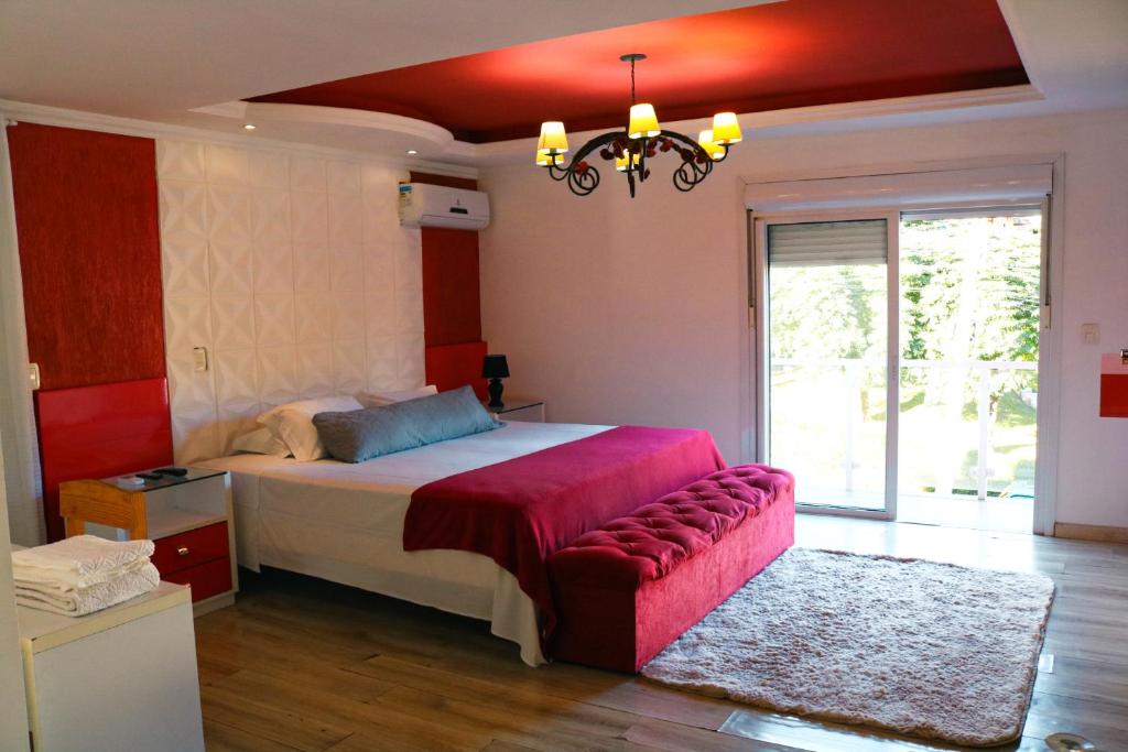 格拉玛多Amber 449的一间卧室配有一张大床和一个吊灯。