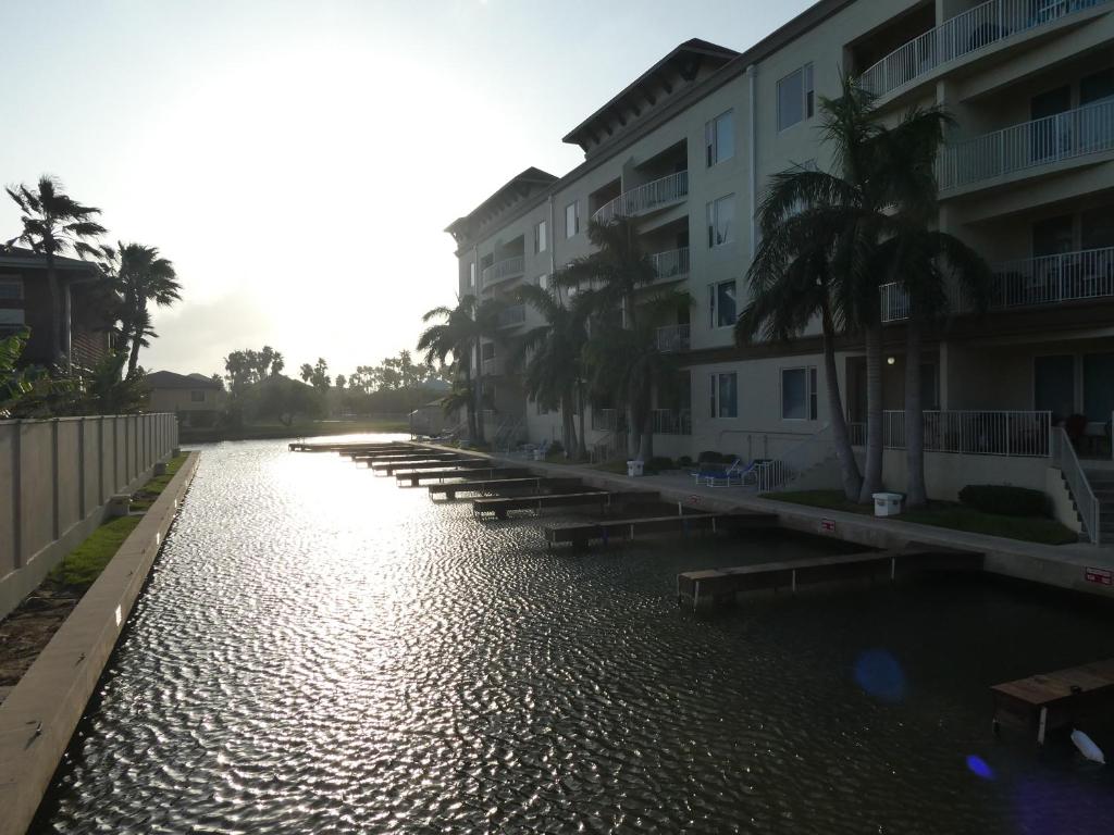 南帕诸岛Las Marinas Condominiums with Boat Docks的一片水,有楼房和棕榈树