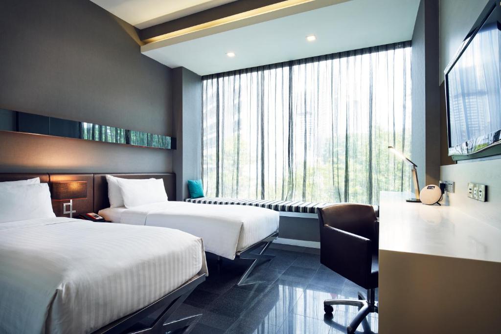 新加坡Quincy Hotel Singapore by Far East Hospitality的酒店客房设有两张床和窗户。