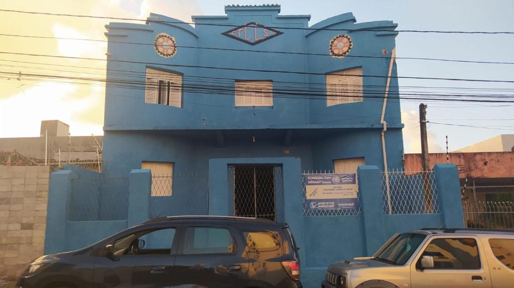 纳塔尔Pousada Cisne Branco的两辆汽车停在蓝色建筑前面