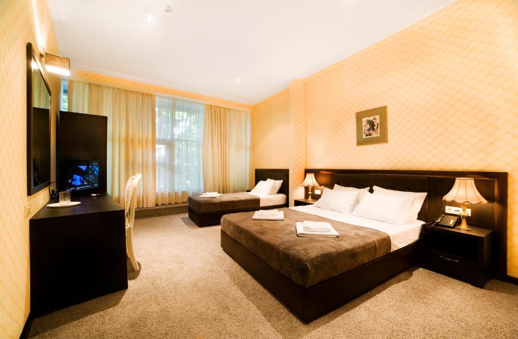 第比利斯卡拉西酒店的大型酒店客房,配有床和沙发