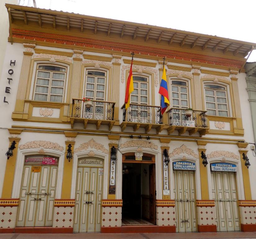 昆卡Hotel La Orquidea的上面有两面旗帜的建筑