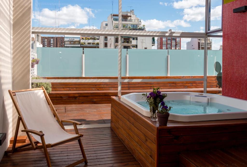 布宜诺斯艾利斯因菲尼托酒店的浴缸位于带椅子的阳台