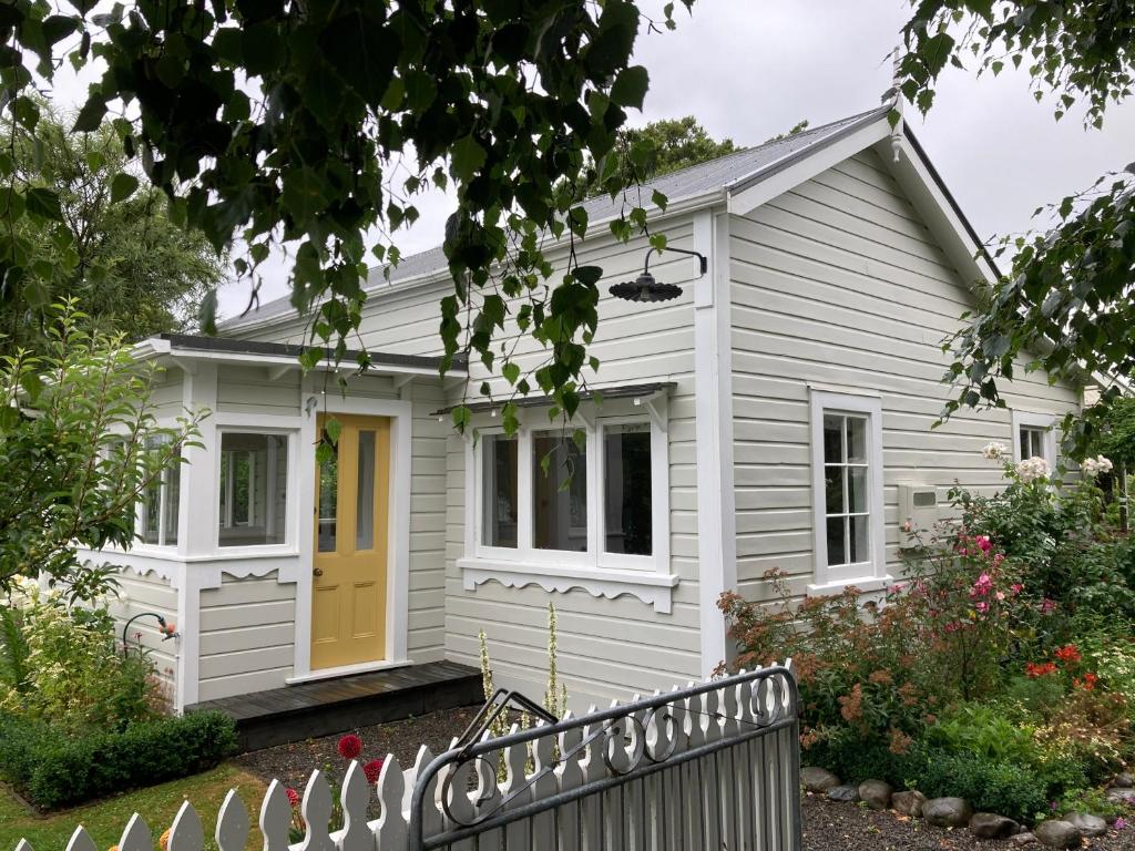 格雷敦Country Bliss Cottage的白色的房子,有黄色的门