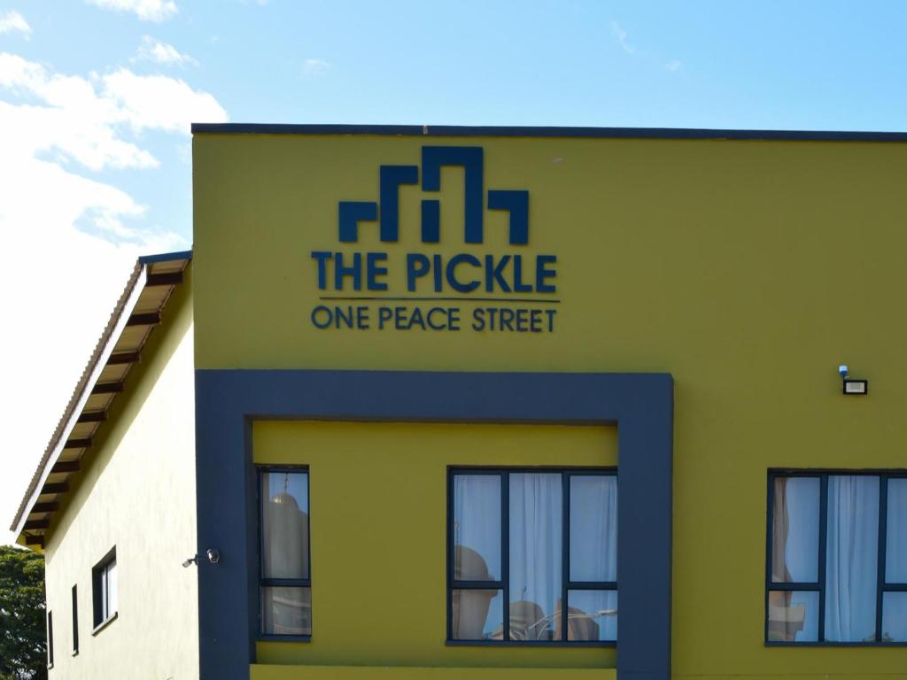察嫩The Pickle Residence的一座黄色和绿色的建筑,一条平和的街道上