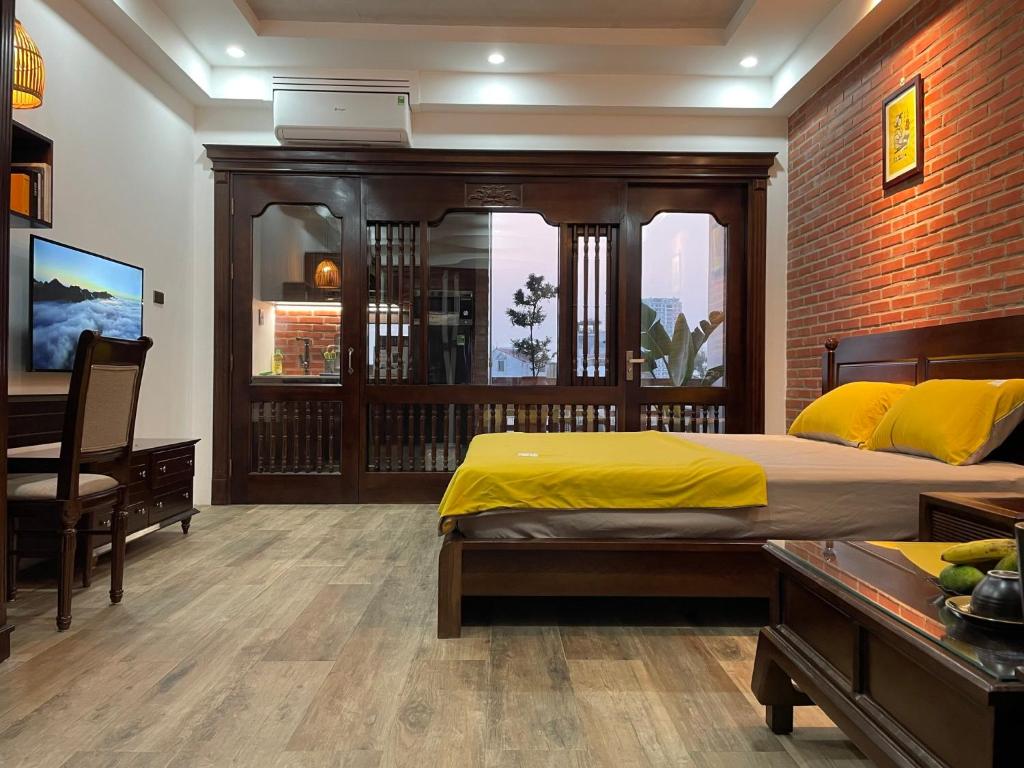 河内Eco Nest的一间卧室配有一张床、一张桌子和一张四柱床。