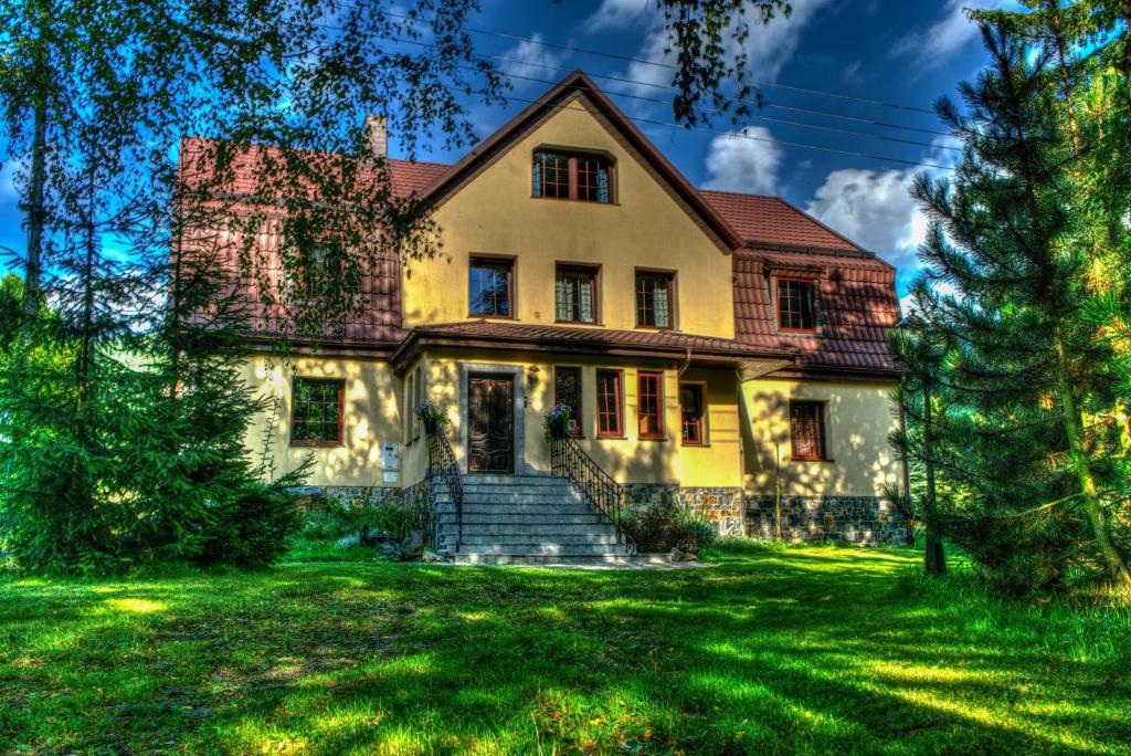 RzeczkaMała Sowa的绿色草坪上的老房子