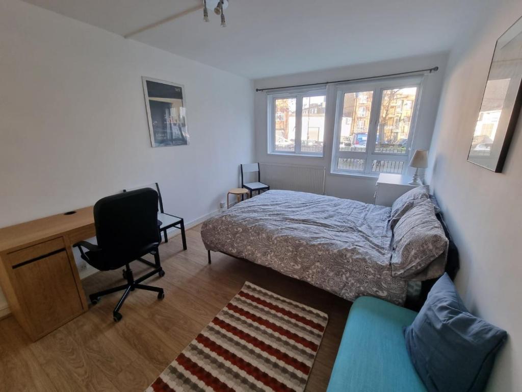 伦敦2 Bedroom Apartment in Kentish Town的一间卧室配有一张床、一张桌子和一把椅子