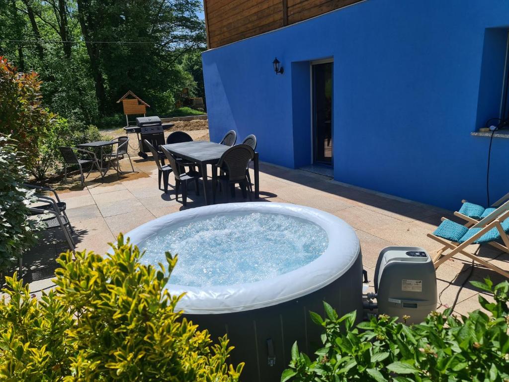 BréchaumontAgréable appartement avec Spa proche de la forêt的庭院内的热水浴池,配有桌椅