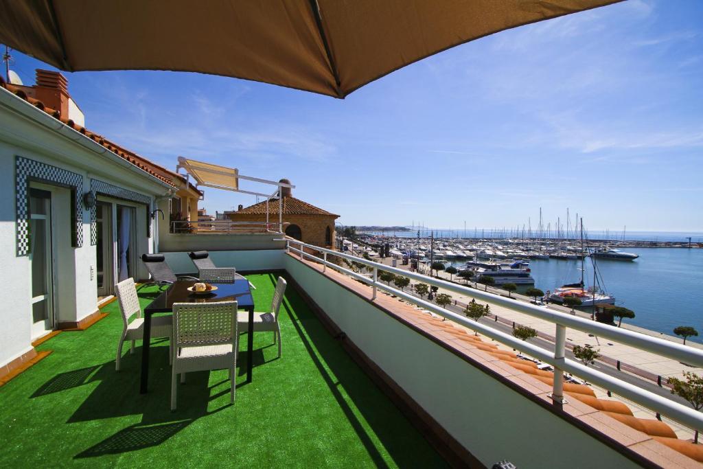 坎布里尔斯Portmarina Planet Costa Dorada的阳台配有桌椅,享有海港的景致。
