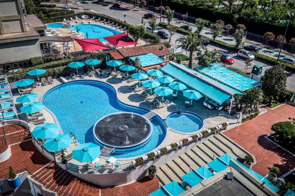 索托马里纳B&B Hotel Chioggia Airone的享有带蓝伞的游泳池的顶部景致