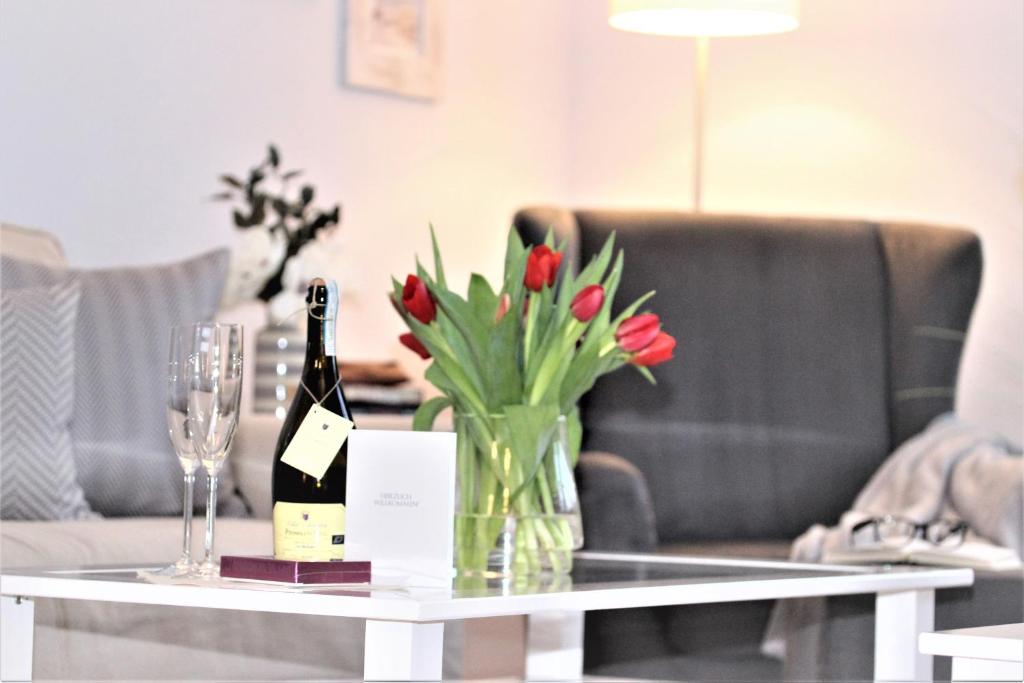 青斯特KranichSuite - Zingst的一张桌子,上面放着花瓶和一瓶葡萄酒