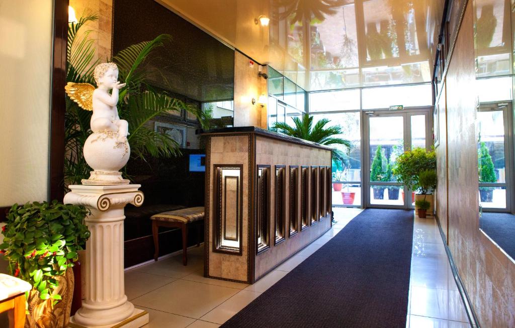 阿德勒雅典娜酒店的大厅,建筑里有雕像和植物