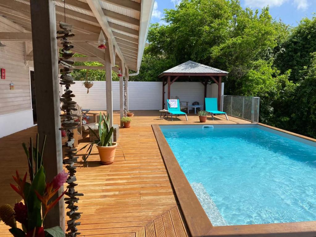 勒迪亚芒VILLA DIAMANTILLES - MAISON D'HOTES的一个带游泳池和凉亭的庭院